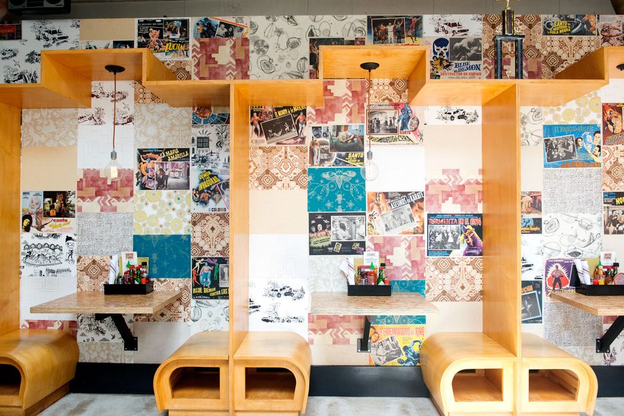 Orange booths against a collage wall of vintage prints