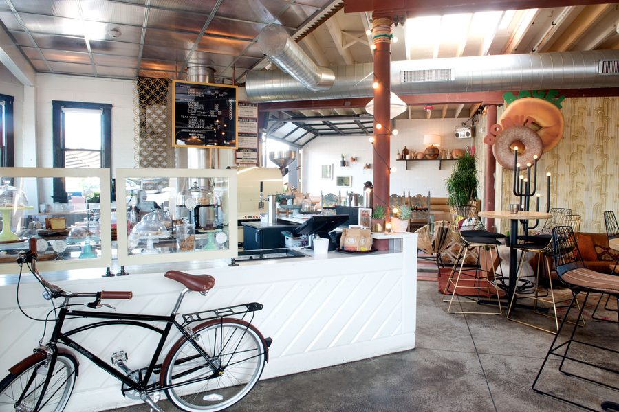 The white coffeehouse counter with a vintage bicycle out front