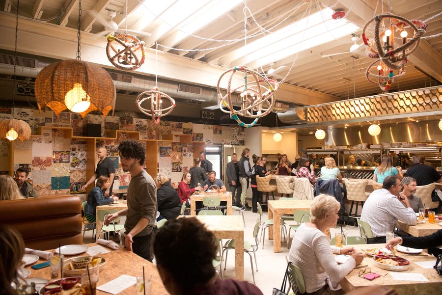 A full dining room under Honcho's rope-wrapped chandeliers
