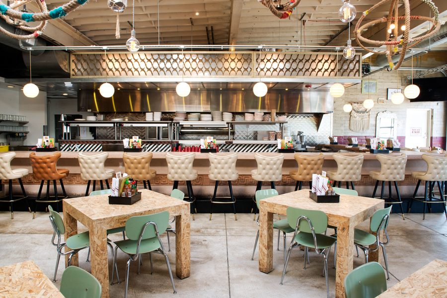 Honcho's dining room with mint chairs and an open kitchen