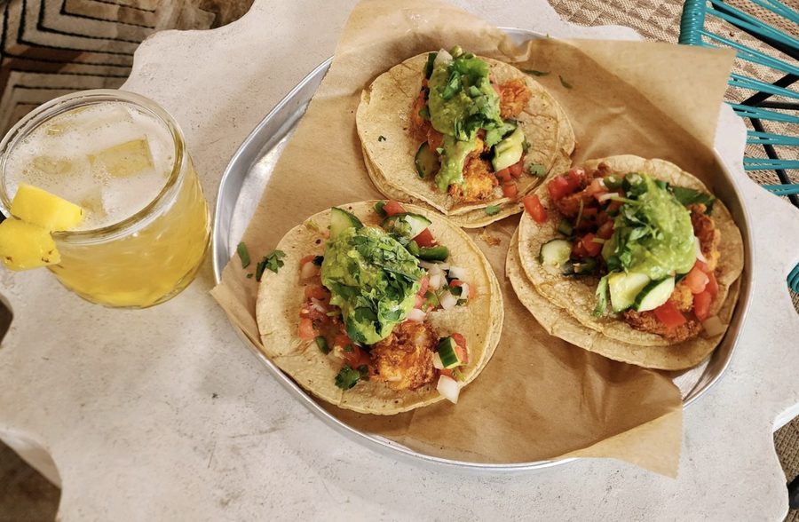 Tacos on parchment next to a cocktail